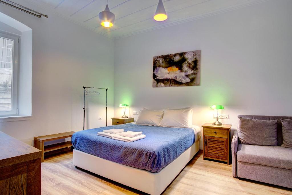 um quarto com uma cama, um sofá e uma cadeira em Casa Nektaria em Corfu Town