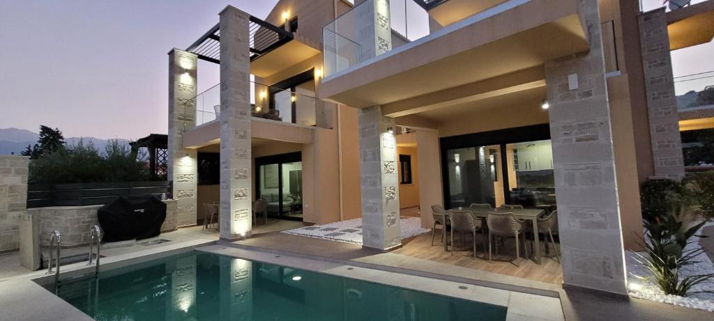 una casa con piscina frente a una casa en Splendid Villas and Family Resort, en Kalamitsi Amygdali
