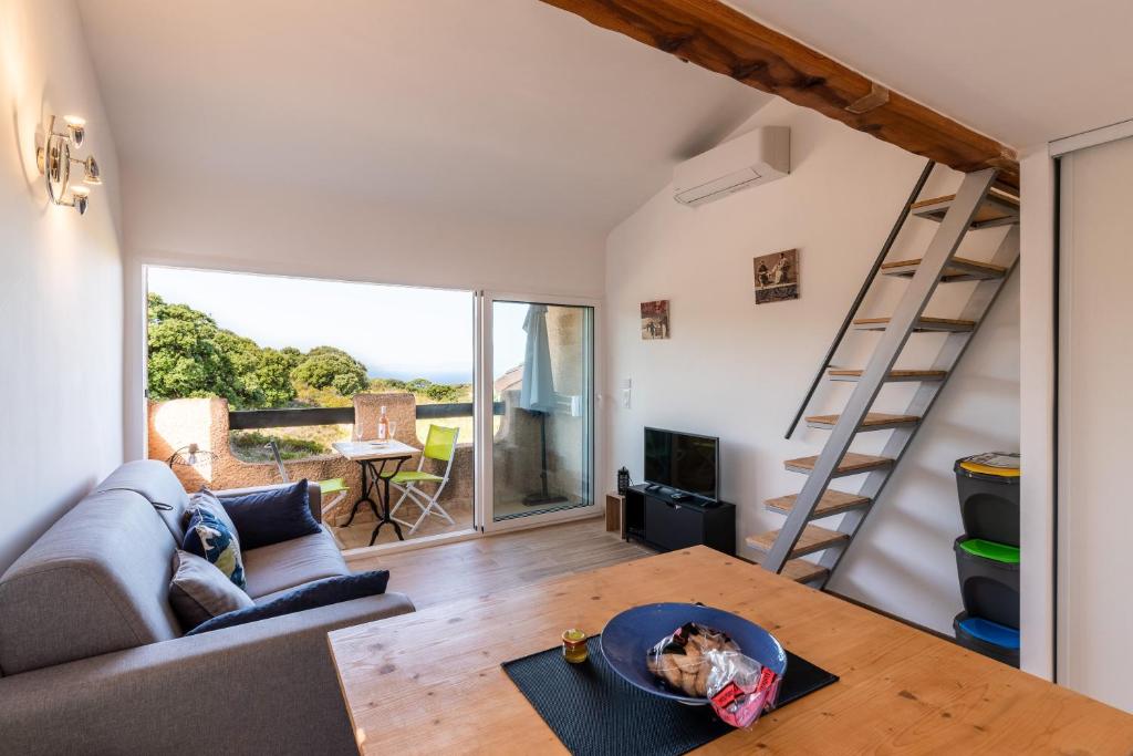 un piccolo soggiorno con divano e tavolo di Ambroggio - Grand studio avec mezzanine - Vue Mer a Lumio