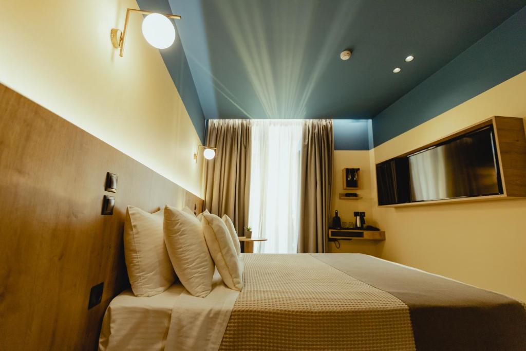 um quarto com uma cama com um tecto azul em Metis Urbane Living Spaces em Atenas