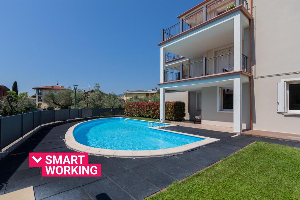 a villa with a swimming pool in front of a house at Appartamento in Villa Beatrice PT7 by Wonderful Italy in Toscolano Maderno