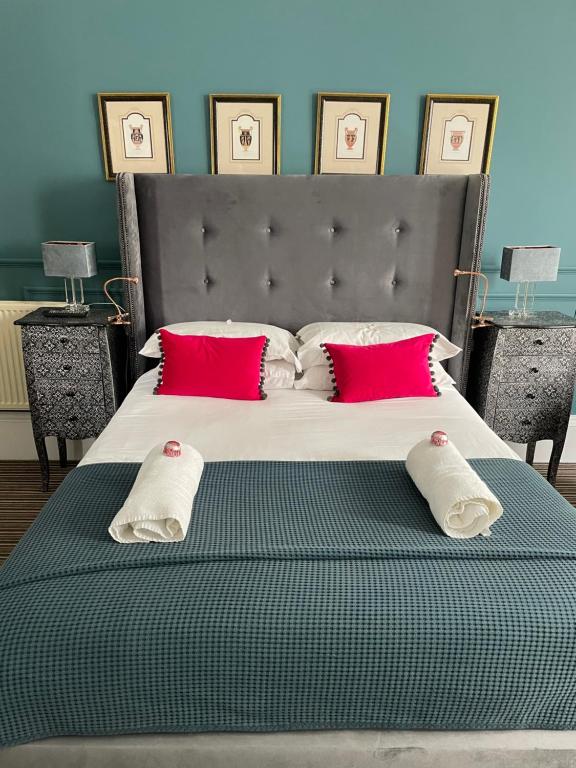 a bed with a red blanket and a white pillow on top of it at Albyn Townhouse in Edinburgh