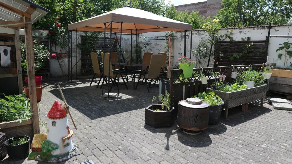 un patio con sombrilla y una mesa con macetas. en Ferienwohnung Rosenstadt, en Forst