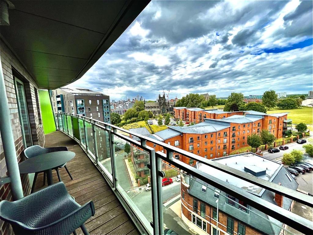 a balcony with a chair and a view of a city at Chic Leeds City Apartment, Free Parking, Balcony in Leeds