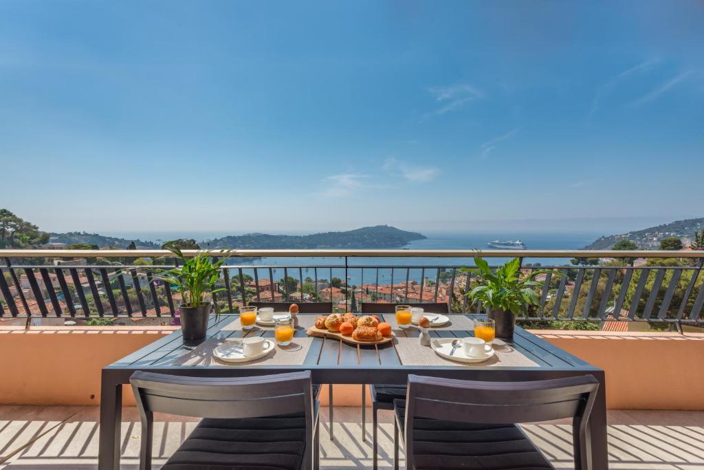 a table with a plate of food on a balcony at Villefranche Bay View in Villefranche-sur-Mer