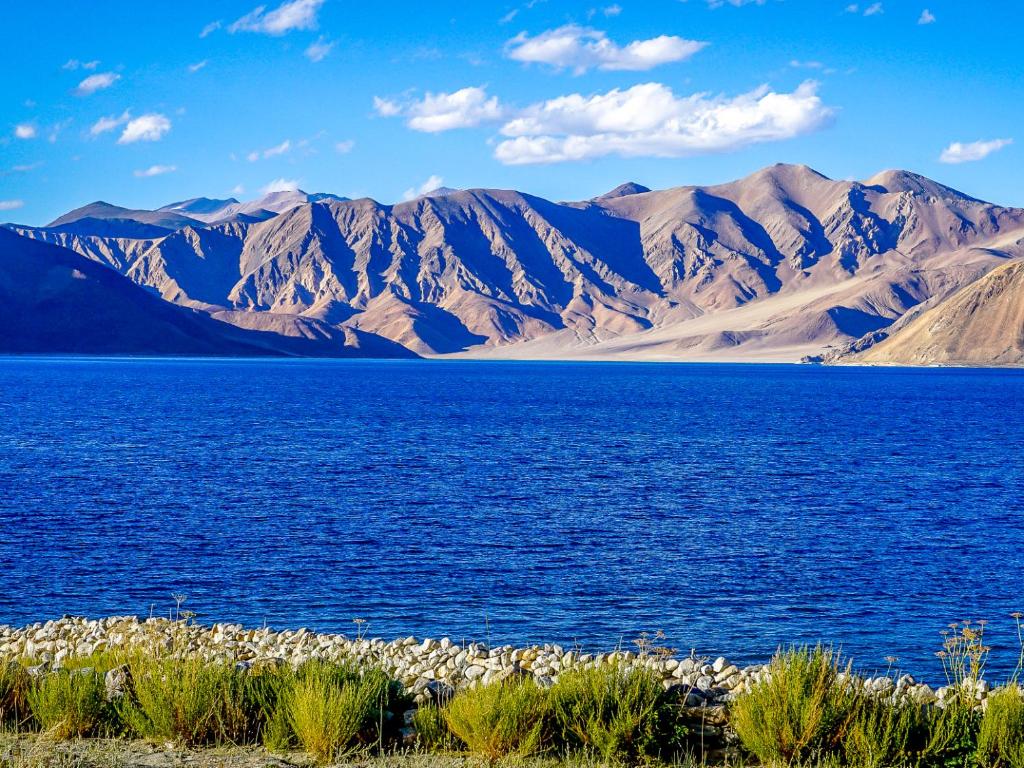 a lake with mountains and a mountain range at MH - Pangong Homestay - B in Spangmik