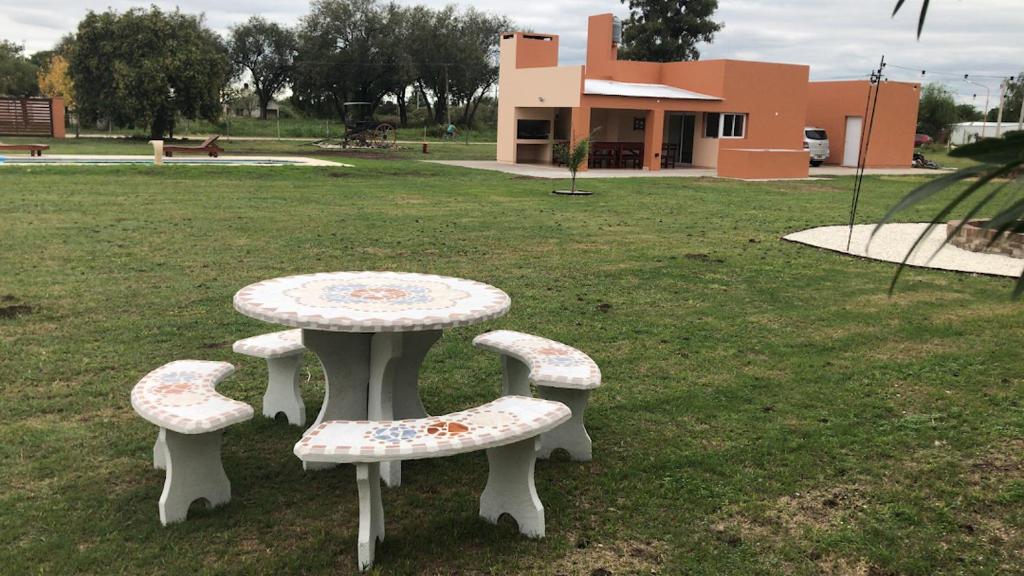 un tavolo e tre panche sedute nell'erba di Los Sunchos Casa de Campo a Ataliva
