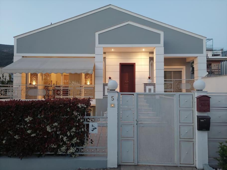 a white house with a fence in front of it at La maison de Catherine in Volos