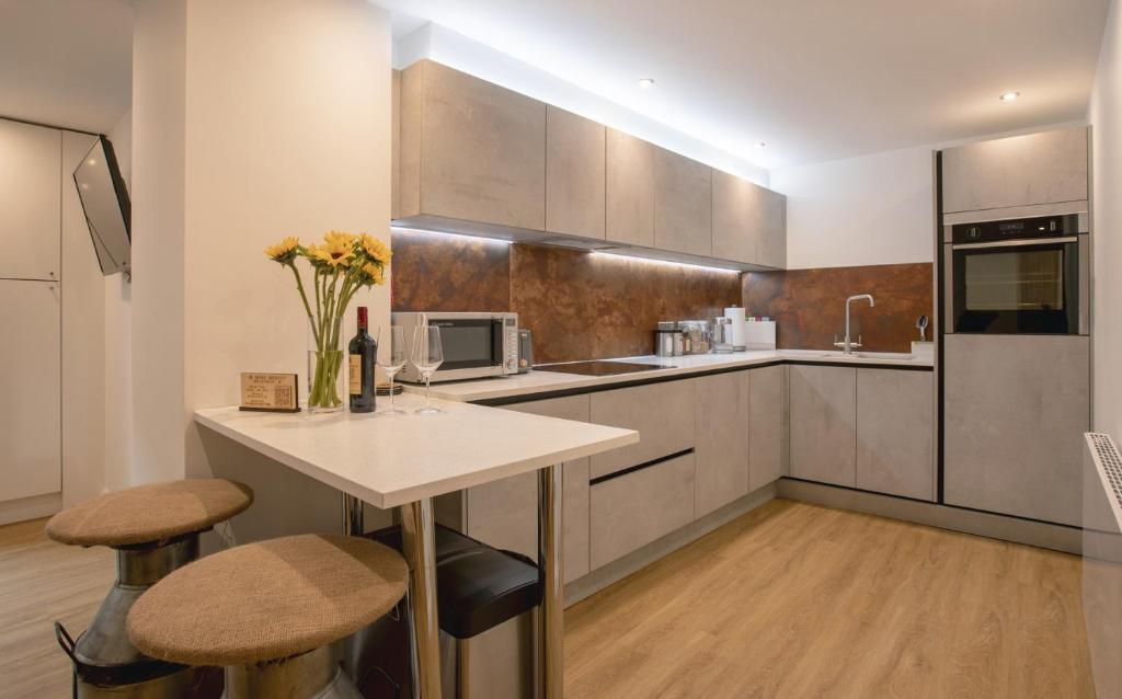 una cucina con tavolo e due sgabelli di no 1 Wood Street a Swindon