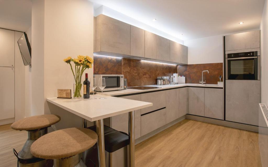 a kitchen with a table and two stools in it at no 1 Wood Street in Swindon