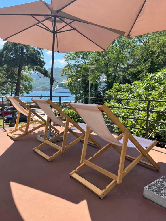 a row of lounge chairs and an umbrella at Apartments Vojvoda in Kotor