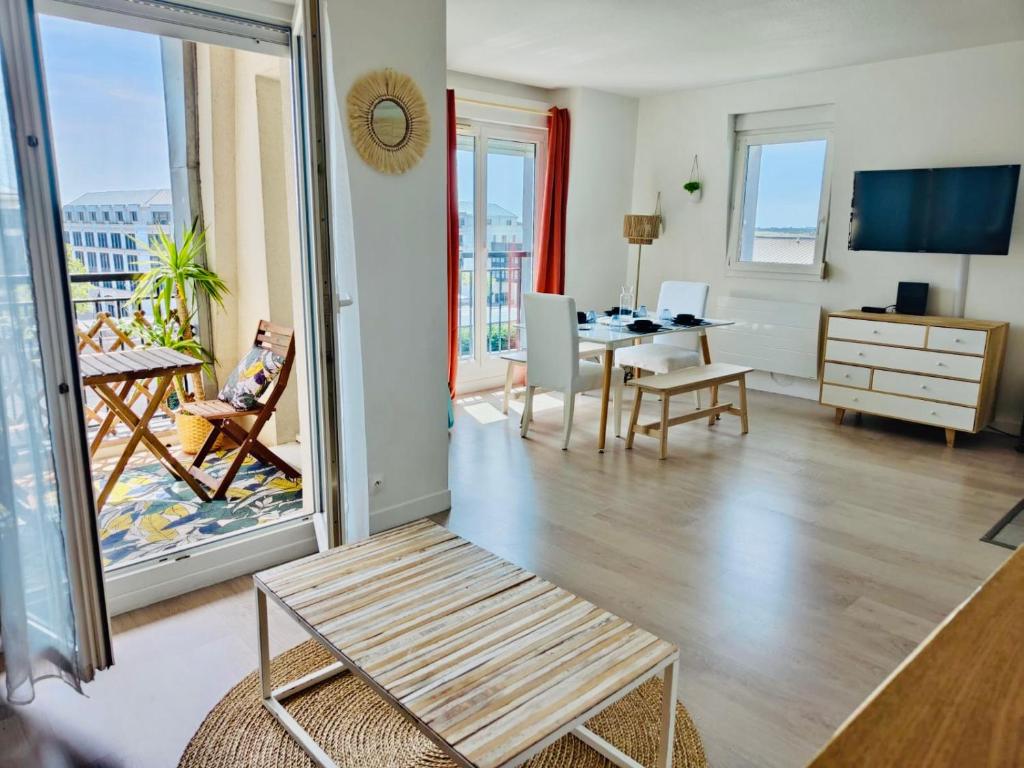 ein Wohnzimmer mit Blick auf einen Balkon in der Unterkunft Suite Villanova Near Disneyland Paris in Chessy