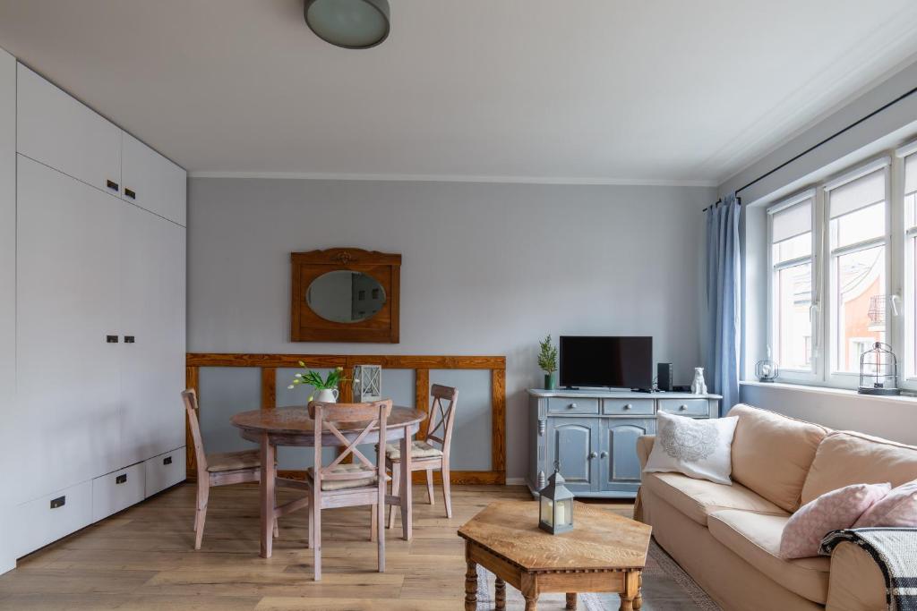 a living room with a table and a couch at Apartament Stare Miasto in Elblag