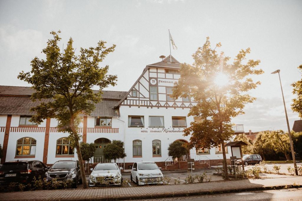 a building with cars parked in front of it at Fährhaus Kirschenland in Jork