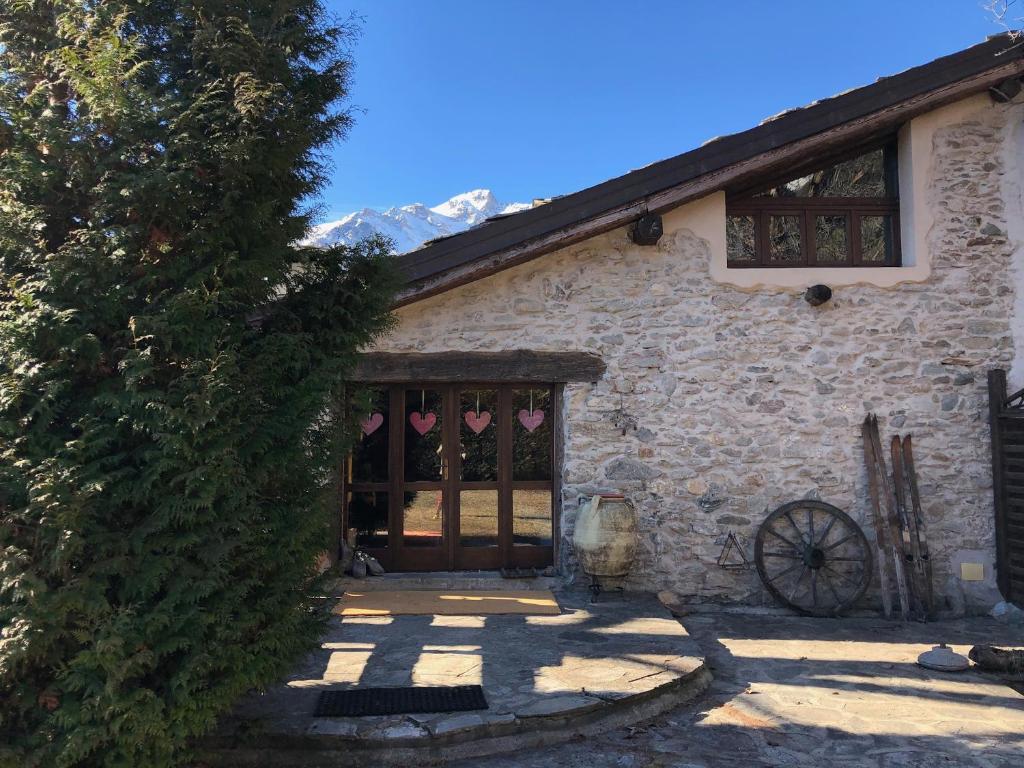 uma casa de pedra com uma grande porta e uma janela em Vacanze in Baita di charme Alta Val di Susa Oulx em Savoulx