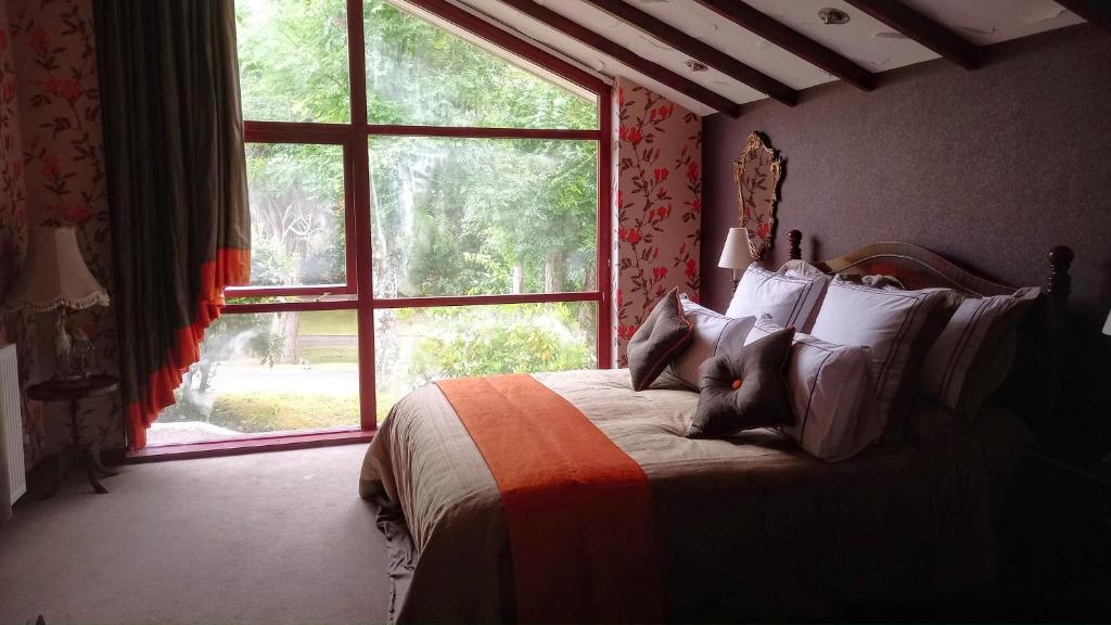 um quarto com uma cama e uma janela grande em Havenwood em Ayr