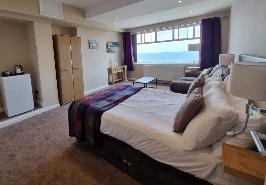a bedroom with a large bed and a living room at The Ramleh in Scarborough