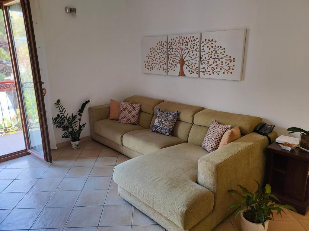 Visitponza - Vesta في بونسا: غرفة معيشة مع أريكة وصورة شجرة على الحائط