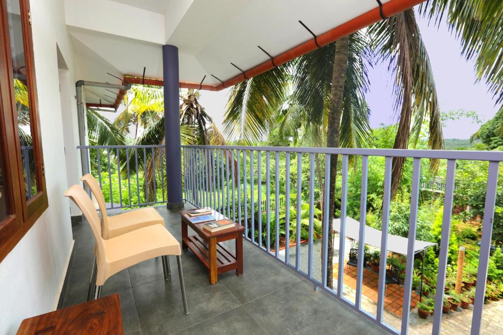 a balcony with a chair and a table at Monsoon Apartments in Kannur