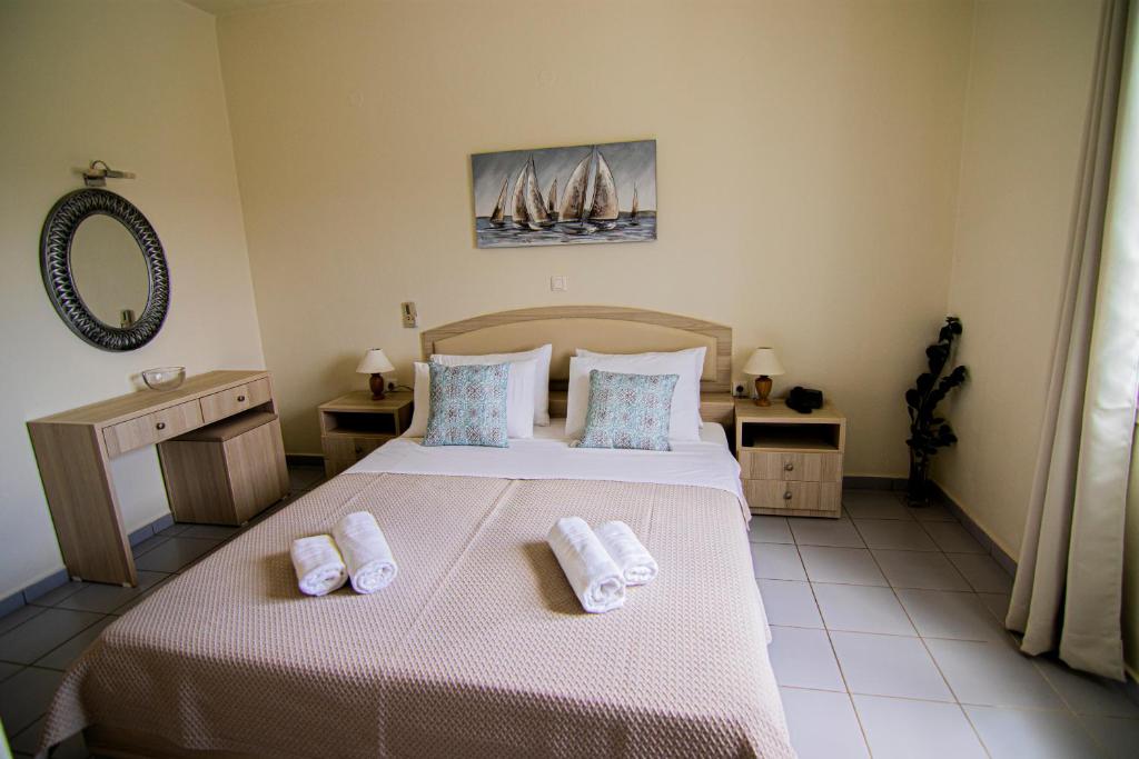 a bedroom with a bed with two towels on it at Castri Village Hotel in Palekastron