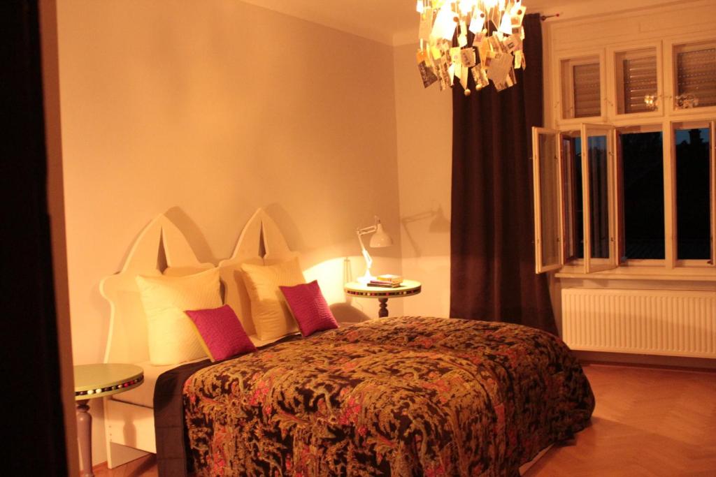 Schlafzimmer mit einem Bett und einem Kronleuchter in der Unterkunft Altstadthaus Cityappartements in Graz