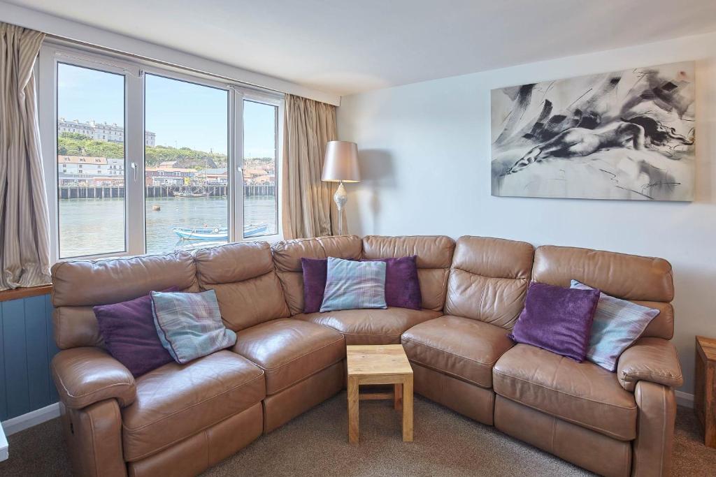 a living room with a brown leather couch with purple pillows at Host & Stay - The Haven in Whitby