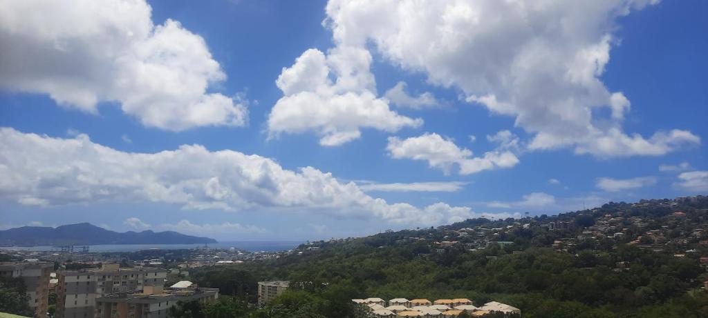 una vista de una ciudad con nubes en el cielo en Super appartement T3 proche de tout sans vis-à-vis, en Fort-de-France