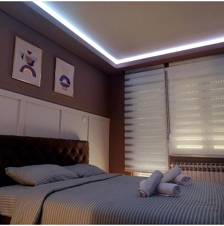 a bedroom with a bed with two stuffed animals on it at Apartman Tadeus in Soko Banja