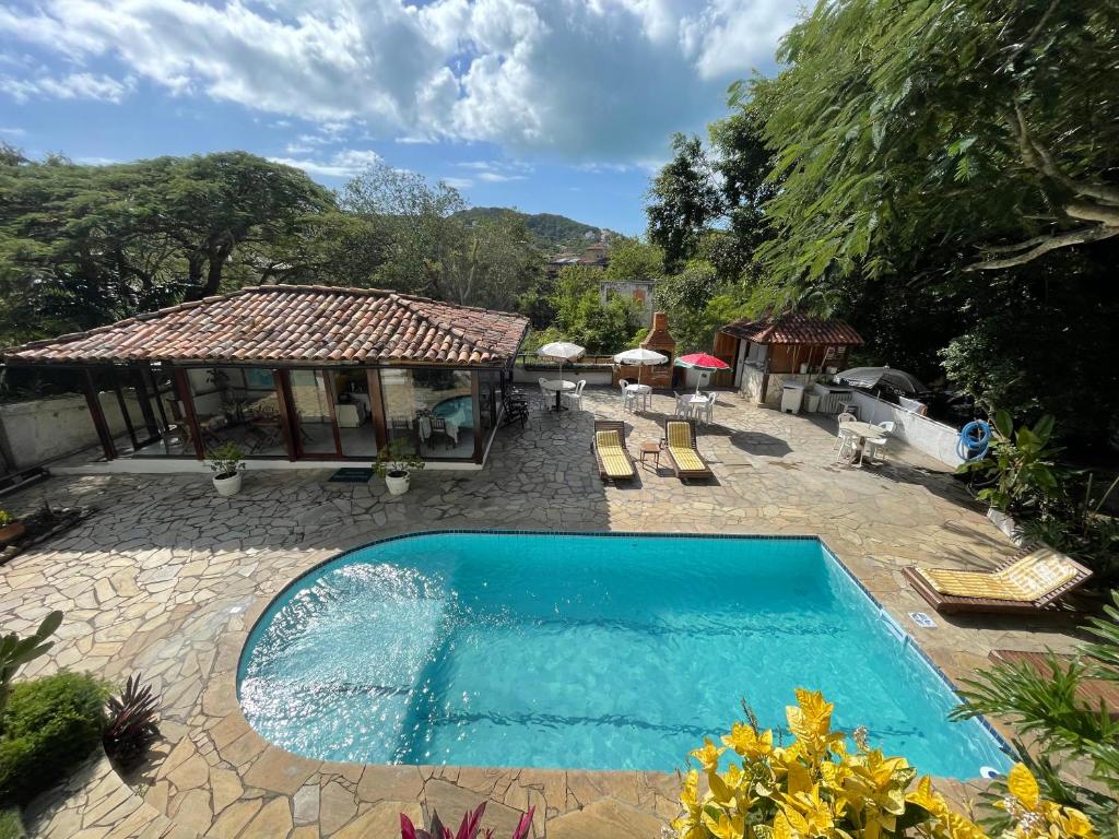 uma piscina num quintal com um pavilhão em Pousada Saint Germain em Búzios