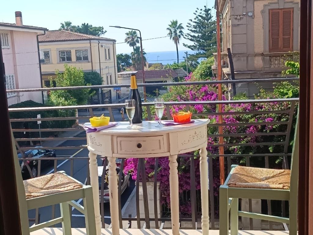 a table with a glass of wine on a balcony at Appartamento Cavaliere Tropea in Tropea