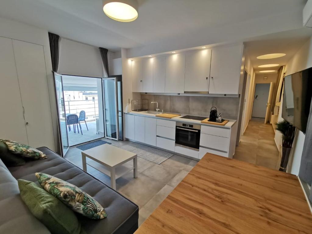 a kitchen and living room with a couch and a table at Ikarus Modern Apartment at the Centre of Athens in Athens