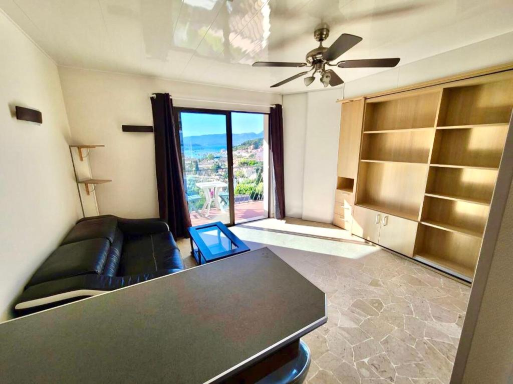 un salon avec un canapé et un ventilateur de plafond dans l'établissement Appartement 2 pièces vue mer avec balcon/terrasse, à Saint-Mandrier-sur-Mer