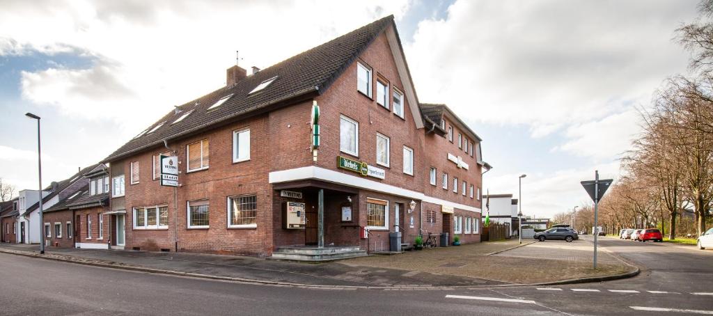 a large brick building on the corner of a street at Hotel Schwung in Bocholt