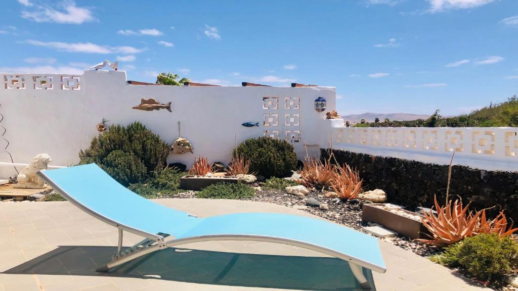 a blue chair in the yard of a house at Maya Powered by SolymarCalma in Costa Calma