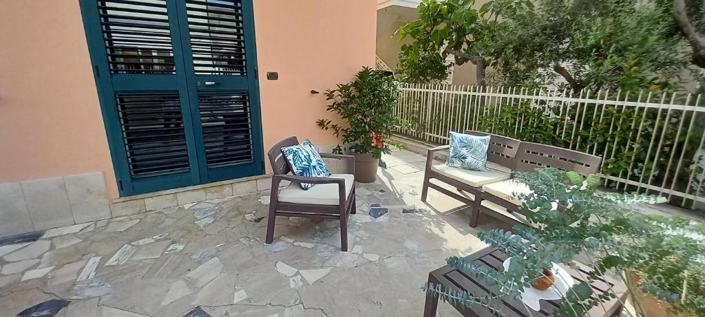 un patio con 2 bancos y una puerta azul en La Maison à la Mer - Appartamentino a 200 mt dal mare, en Giulianova