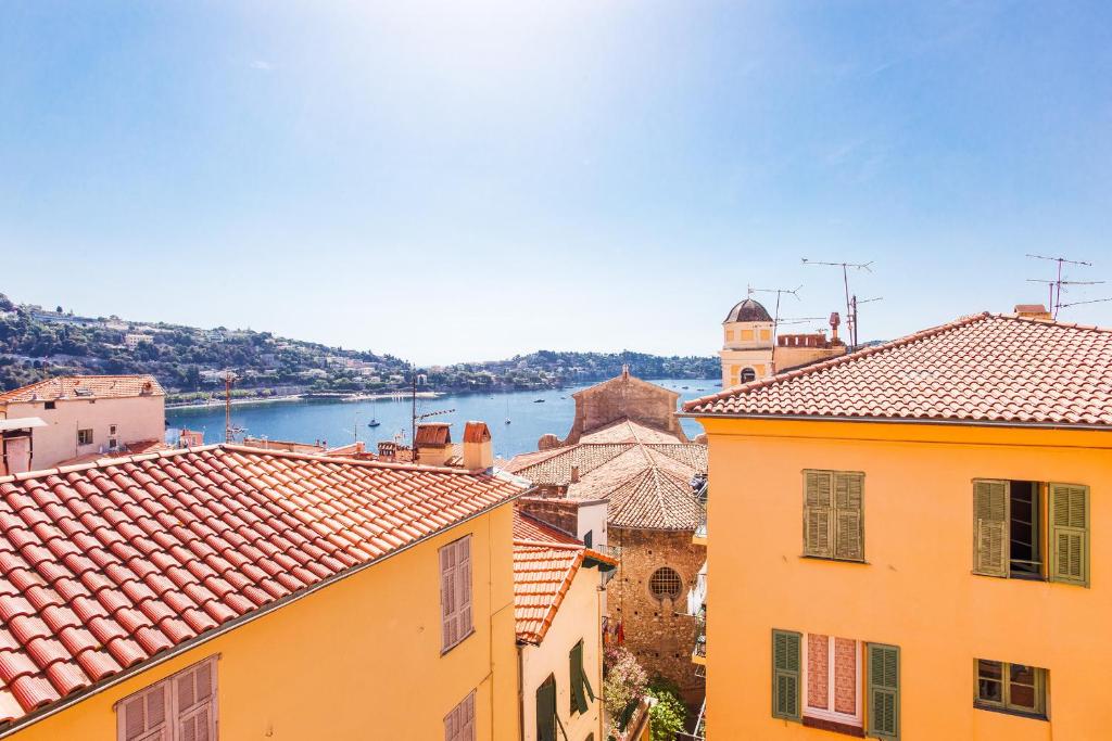 a group of buildings with a river in the background at View on the Bay AP4294 By Riviera Holiday Homes in Villefranche-sur-Mer