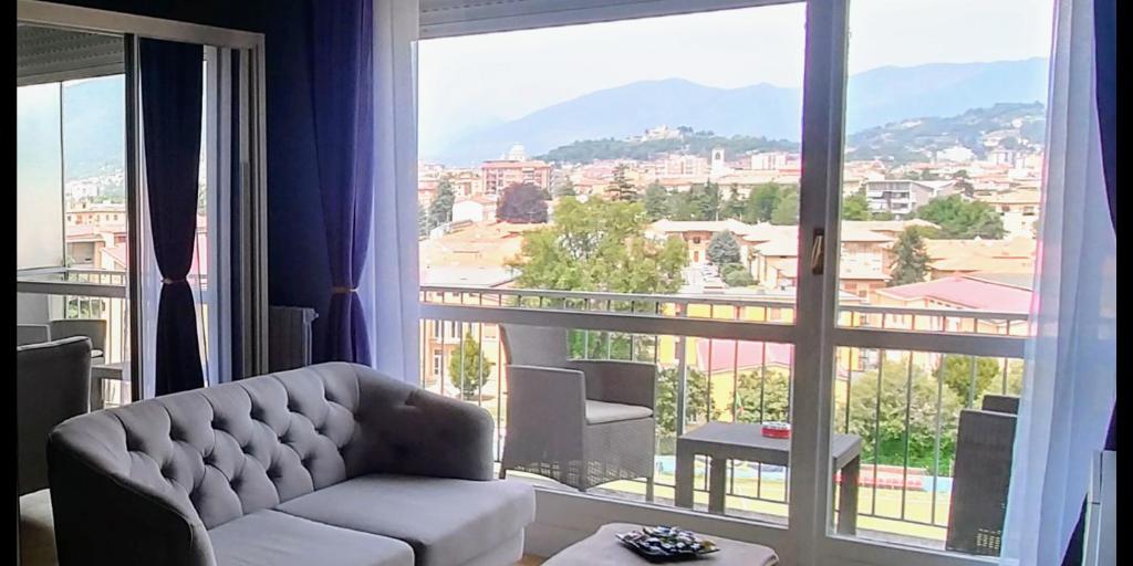 a living room with a couch and a large window at SUITE PANORAMA in Brescia