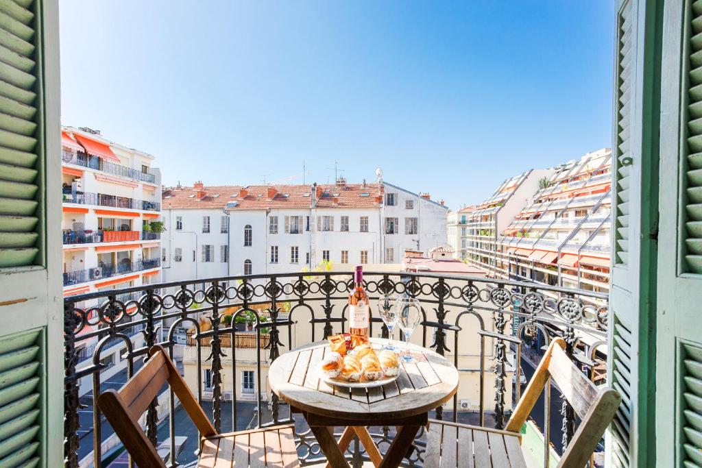 une table avec une assiette de nourriture sur un balcon dans l'établissement LUNG ARNO AP4300 By Riviera Holiday Homes, à Nice