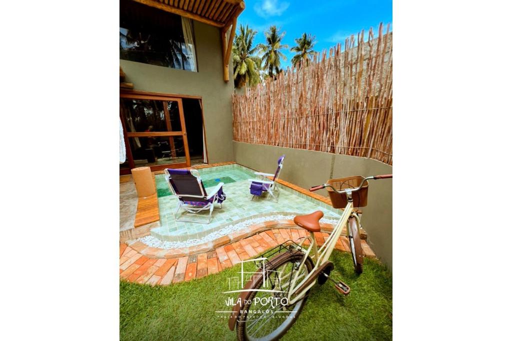 a bike parked in the grass next to a swimming pool at Vila do Porto, Praia do Patacho - Bangalô Patacho in Pôrto de Pedras