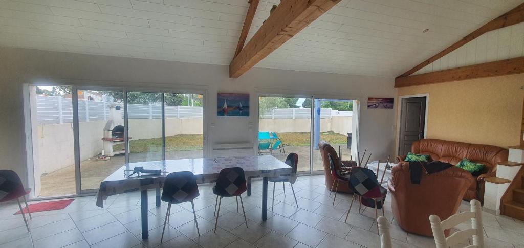 ein Wohnzimmer mit einem Esstisch und Stühlen in der Unterkunft La belle Vendéenne in La Tranche-sur-Mer