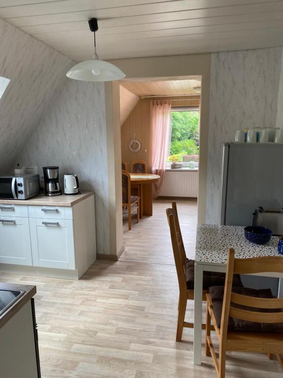 a kitchen and dining room with a table and chairs at Ferienwohnung Meilerplatz – Familienfreundliche Ferienwohnung für max. 4 Personen in Bad Lauterberg am Harz in Bad Lauterberg