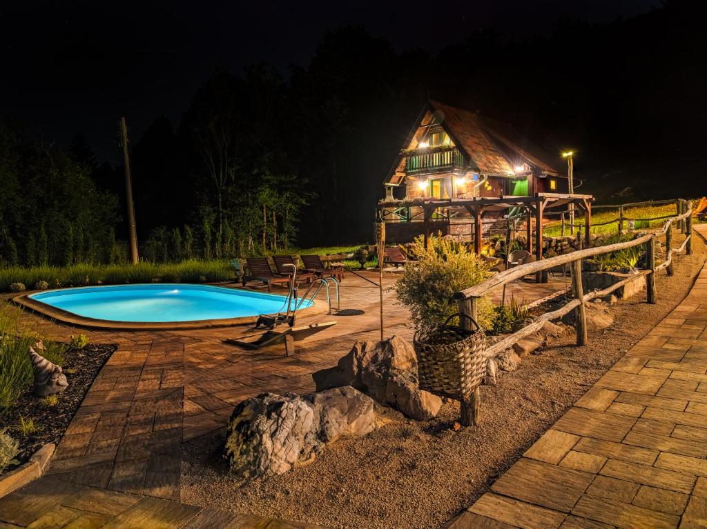 科雷尼察的住宿－Holiday Park Plitvice Paradise，夜间在房子前面的游泳池