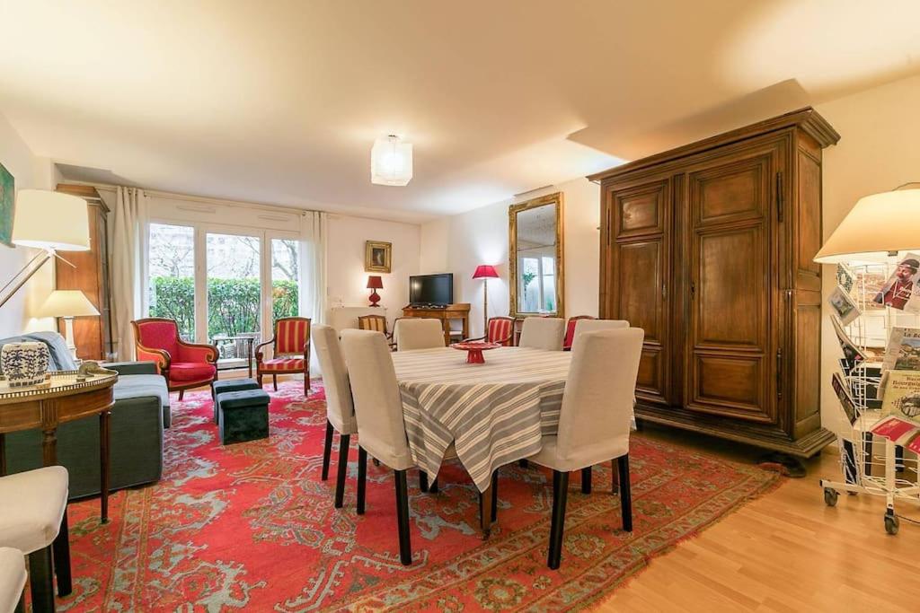 uma sala de jantar com uma mesa e cadeiras num quarto em Les 4 horizons au sein d' une résidence calme em Talant