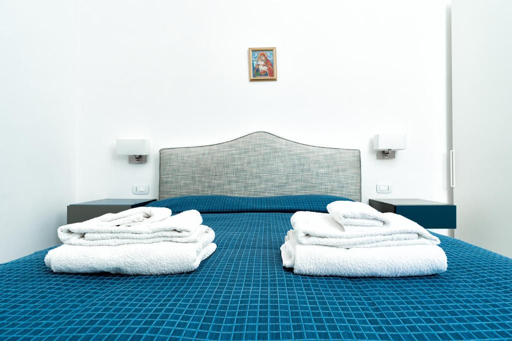 - une chambre avec un lit bleu et des serviettes blanches dans l'établissement La Finestra sul Corso, à Amalfi
