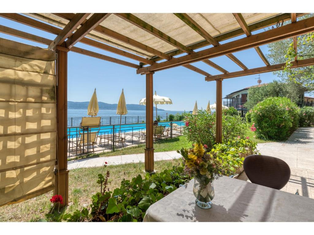 a vase of flowers on a table with a view of the ocean at Villa Cappellina in Toscolano Maderno