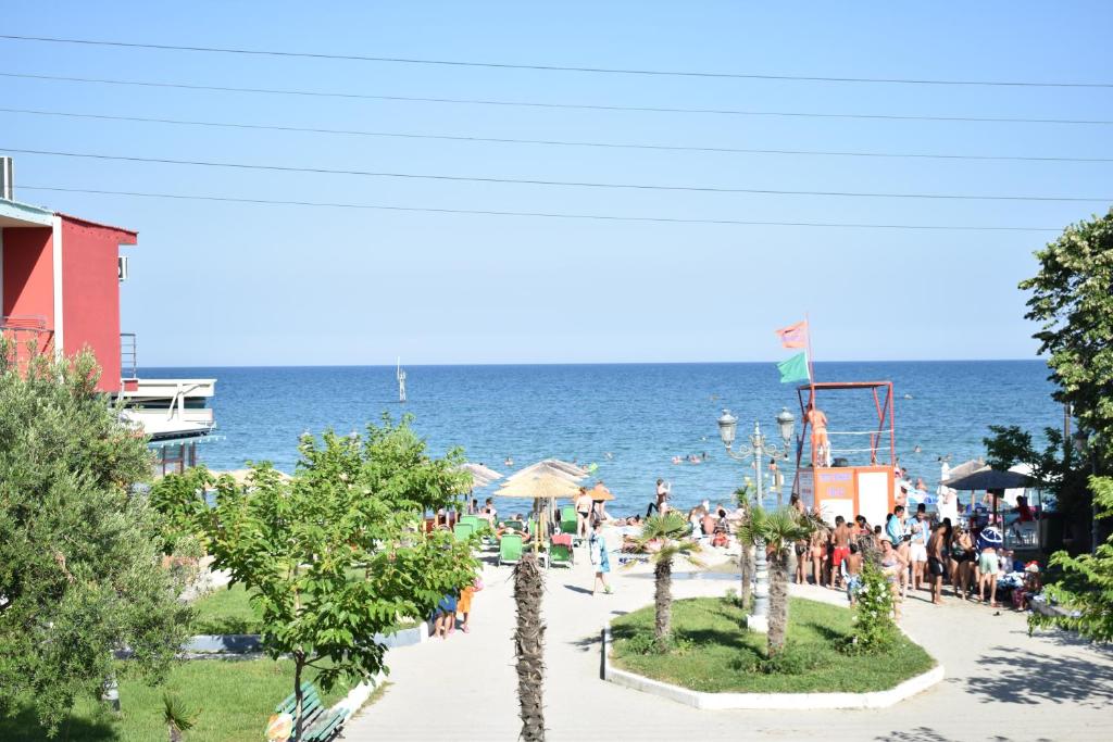 a group of people at a beach with the ocean at Emmanuel Apartments in Paralia Katerinis