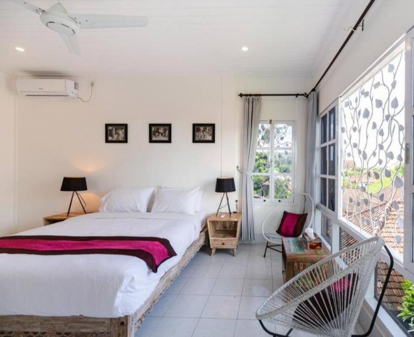 a bedroom with a large bed and a balcony at Beach House Apartment in Legian