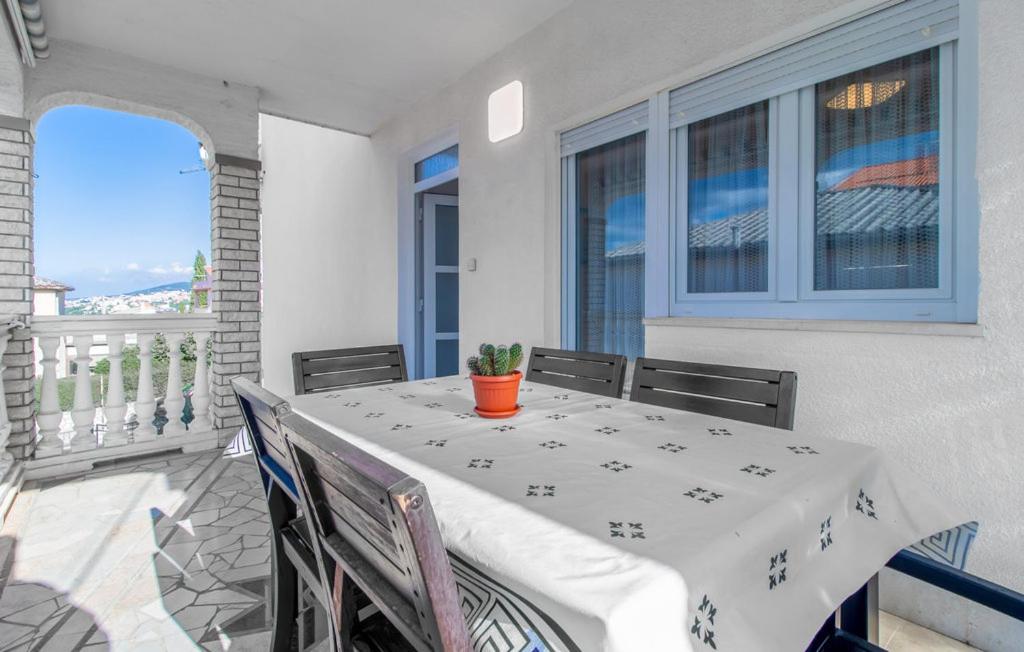 a table with a white table cloth on a balcony at APP 4+1 s dvije spavaće sobe in Selce