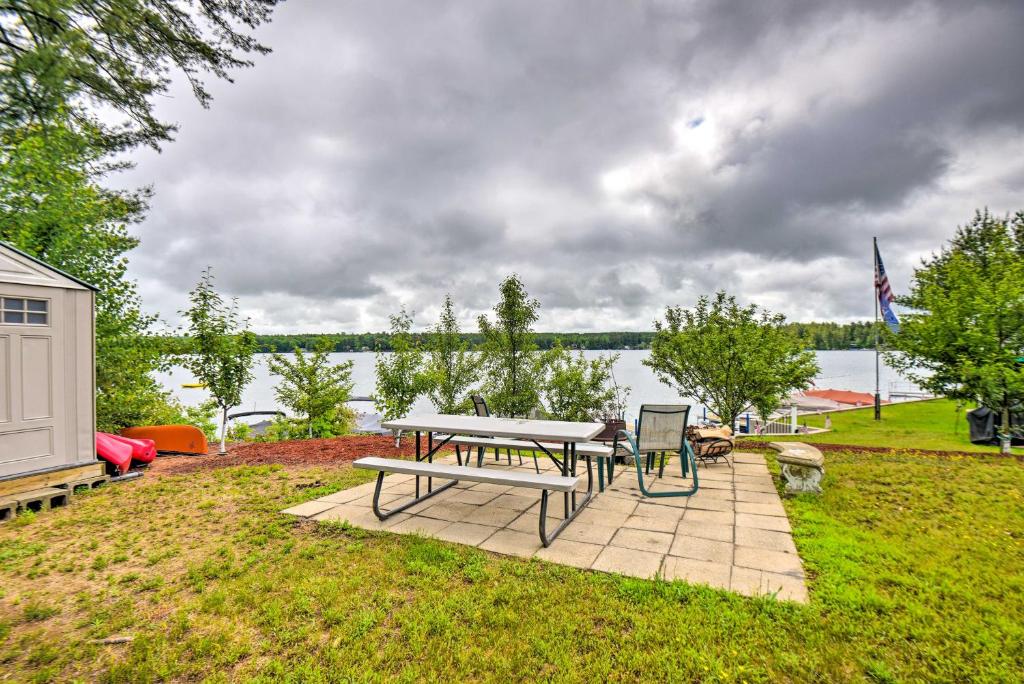una mesa de picnic y sillas en un patio cerca del agua en Scenic Little Ossipee Lake Retreat with Grill! en North Waterboro