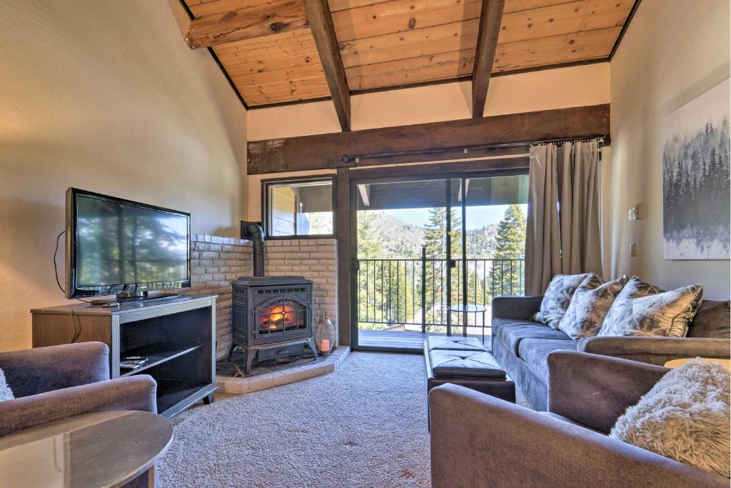 a living room with a couch and a tv and a fireplace at Alpine Meadows Condo with Mtn Views Near Lake Tahoe in Alpine Meadows